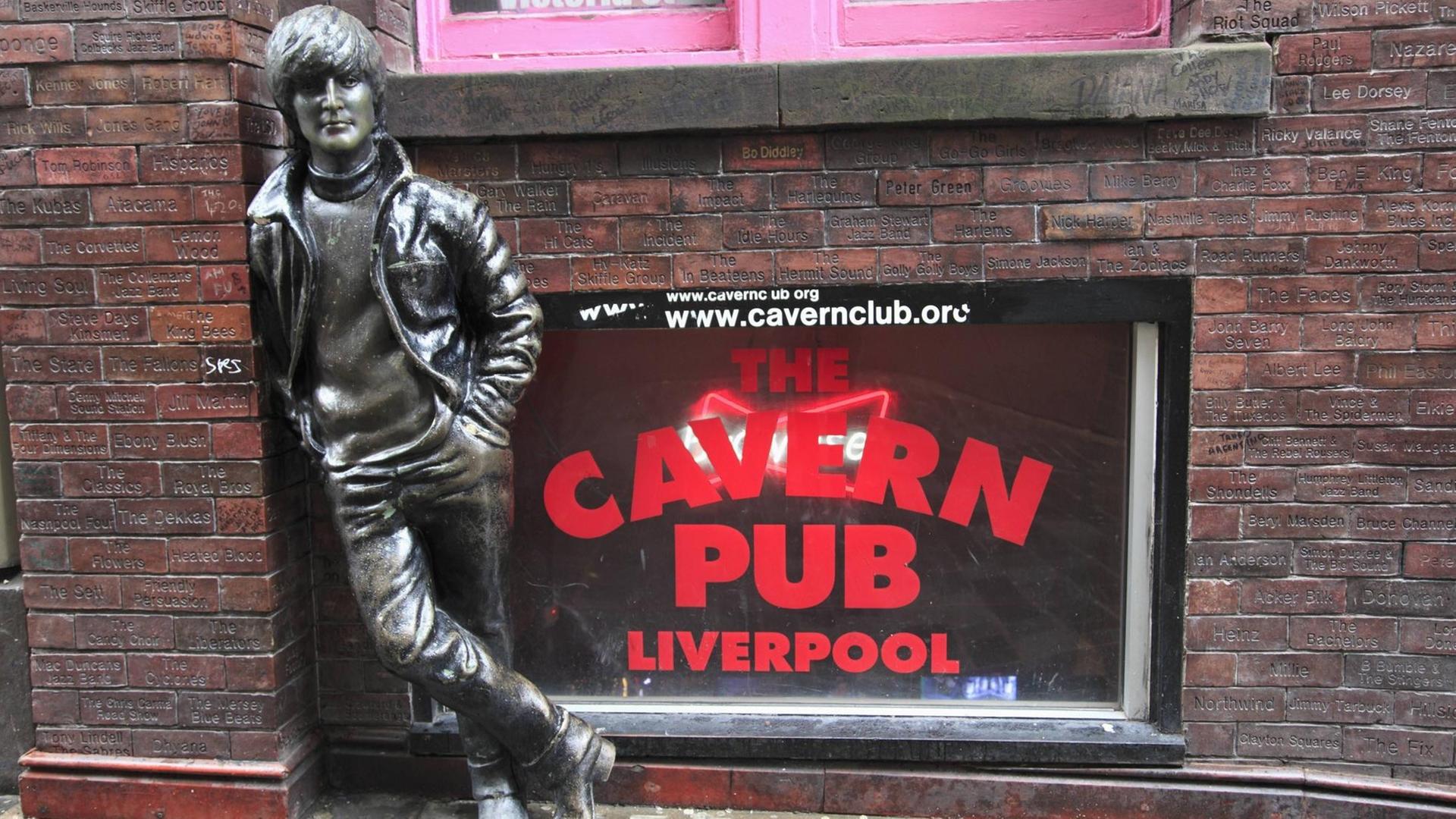 Die John Lennon-Skulptur in der, Mathew Street in Liverpool zeigt den Beatle, wie er sich an einen Eingang lehnt. Die John Lennon-Skulptur in der, Mathew Street in Liverpool zeigt den Beatle, wie er sich an einen Eingang lehnt.