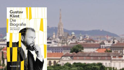 Buchcover "Gustav Klimt - Die Biografie" von Mona Horncastle und Alfred Weidinger, im Hintergrund eine Ansicht von Wien