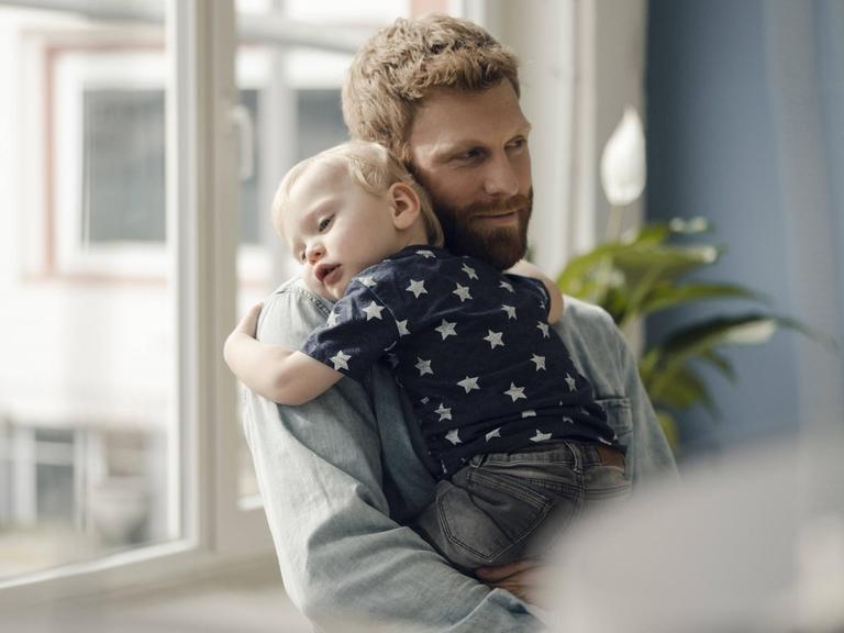 Ein Vater hält seinen Sohn auf dem Arm - Symbolfoto.