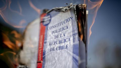 Deitailaufnahem eines brennenden Exemplars der chilenische Verfassung, während des Protestes zum 47. Jahrestag des letzten Militärputsches.