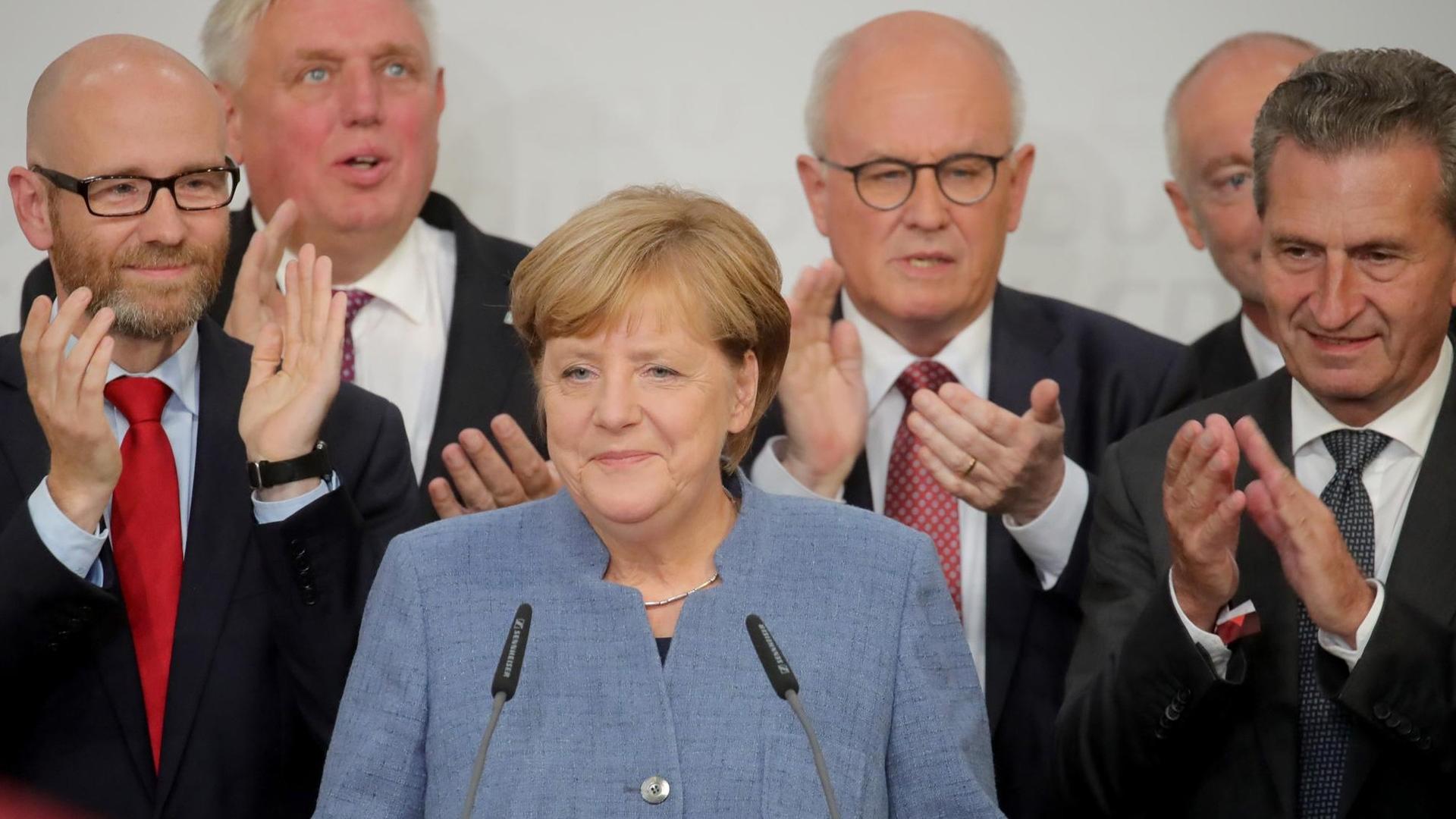 Bundeskanzlerin Angela Merkel (CDU) auf der Bühne in der CDU-Parteizentrale in Berlin, Deutschland, 24. September 2017. Bei der Wahlparty reagierte Merkel auf die ersten Hochrechnungen zur Bundestagswahl. (L-R) CDU-Generalsekretär Peter Tauber, Karl-Josef Laumann, CDU/CSU-Fraktionschef Volker Kauder und EU-Kommissar Günther Oettinger. Bild: Michael Kappeler/dpa Bundeskanzlerin Angela Merkel (CDU) auf der Bühne in der CDU-Parteizentrale in Berlin, Deutschland, 24. September 2017. Bei der Wahlparty reagierte Merkel auf die ersten Hochrechnungen zur Bundestagswahl. (L-R) CDU-Generalsekretär Peter Tauber, Karl-Josef Laumann, CDU/CSU-Fraktionschef Volker Kauder und EU-Kommissar Günther Oettinger. Bild: Michael Kappeler/dpa