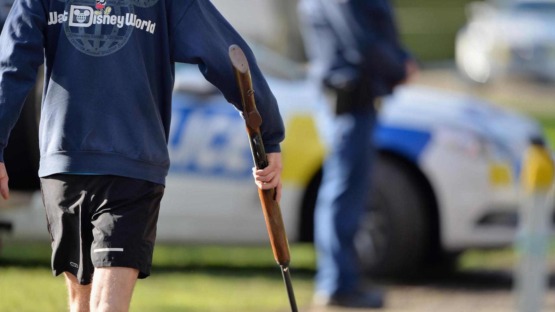 Ein neuseeländischer Waffenbesitzer mit Disney-World-Pullover auf dem Weg zur Abgabe seiner Waffe in Christchurch Ein neuseeländischer Waffenbesitzer mit Disney-World-Pullover auf dem Weg zur Abgabe seiner Waffe in Christchurch