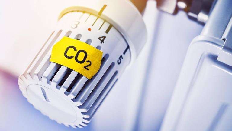 Heizungsthermostat mit CO2-Preisschild Heizungsthermostat mit CO2-Preisschild