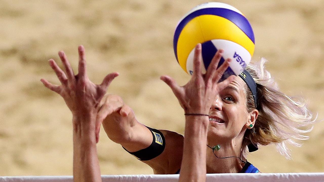Zwei Hände versuchen den Ball von Laura Ludwig über dem Netz zu blocken. Zwei Hände versuchen den Ball von Laura Ludwig über dem Netz zu blocken.