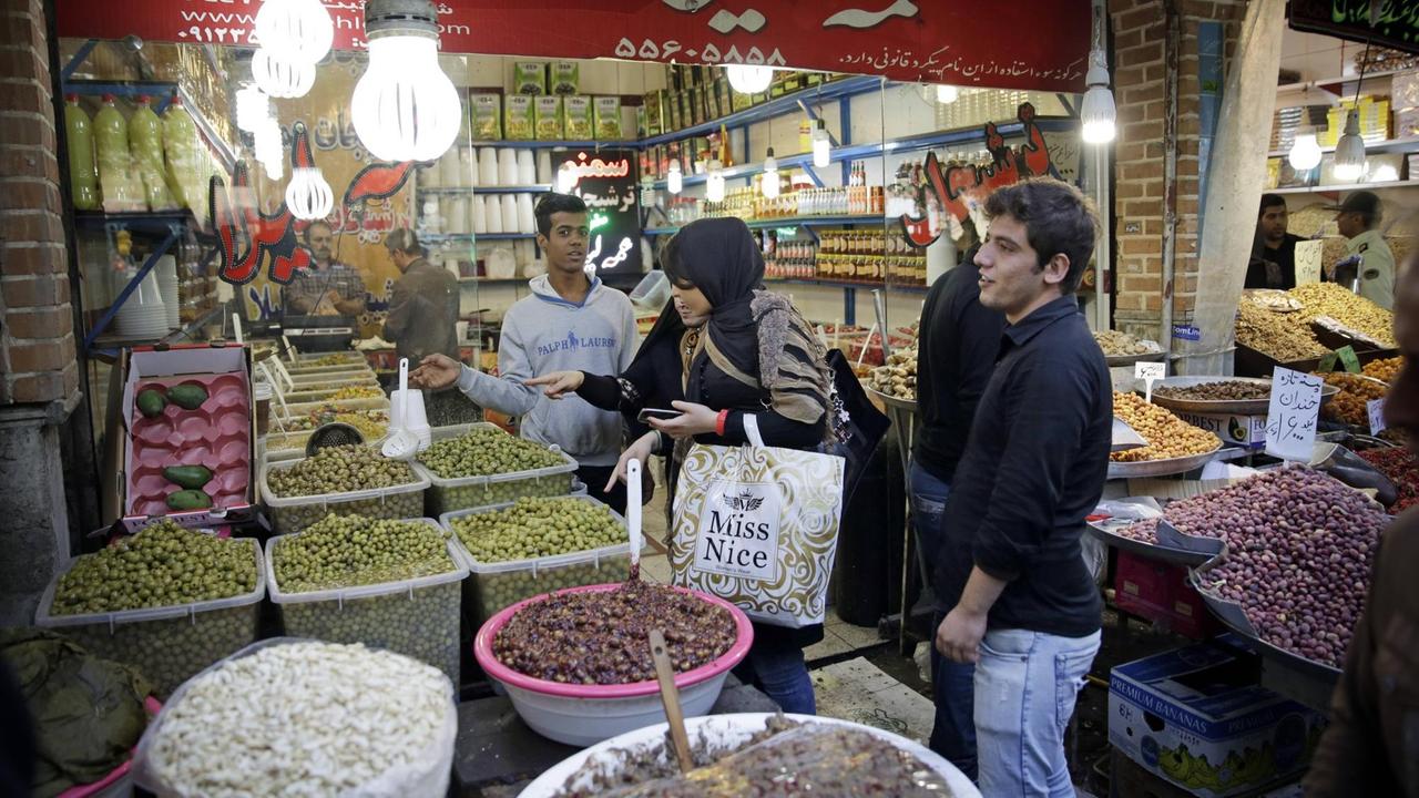 Straßenszene an einem Marktstand: Junge Iranerinnen beim Einkauf von Oliven auf dem Großen Markt in Teheran.