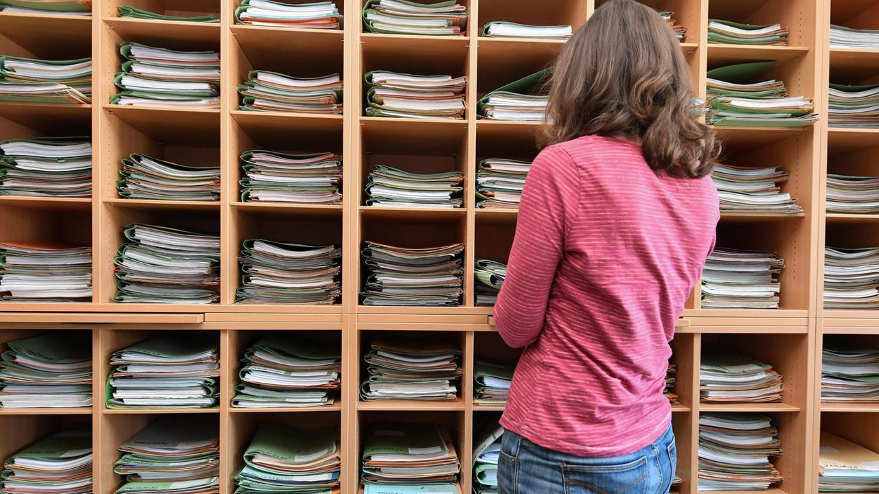 Eine Finanzbeamtin steht vor vielen Akten zu Einkommensteuererklärungen im Finanzamt in Eberswalde (Brandenburg). Eine Finanzbeamtin steht vor vielen Akten zu Einkommensteuererklärungen im Finanzamt in Eberswalde (Brandenburg).