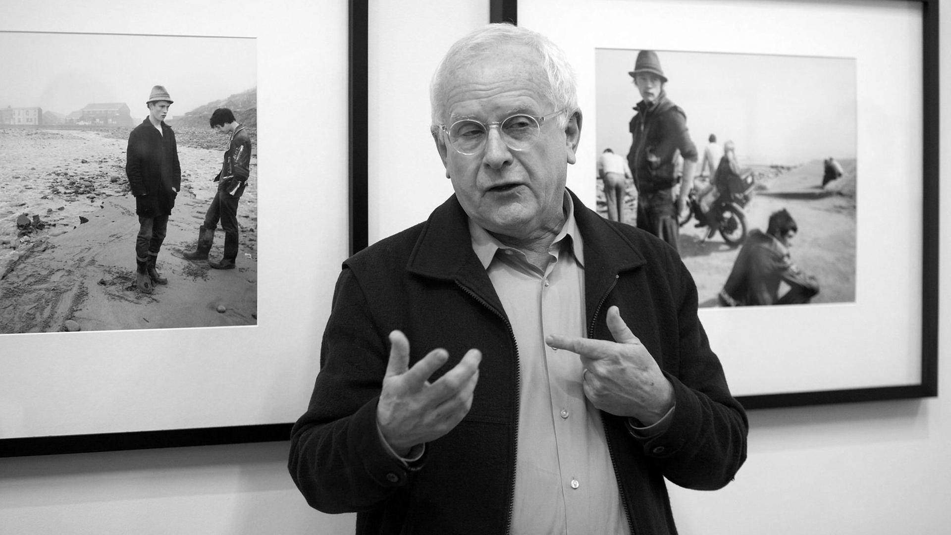 Chris Killip steht bei einer Ausstellung seiner Arbeiten im Folkwang-Museum in Essen vor zwei seiner Fotografien und erzählt über ihre Entstehung.