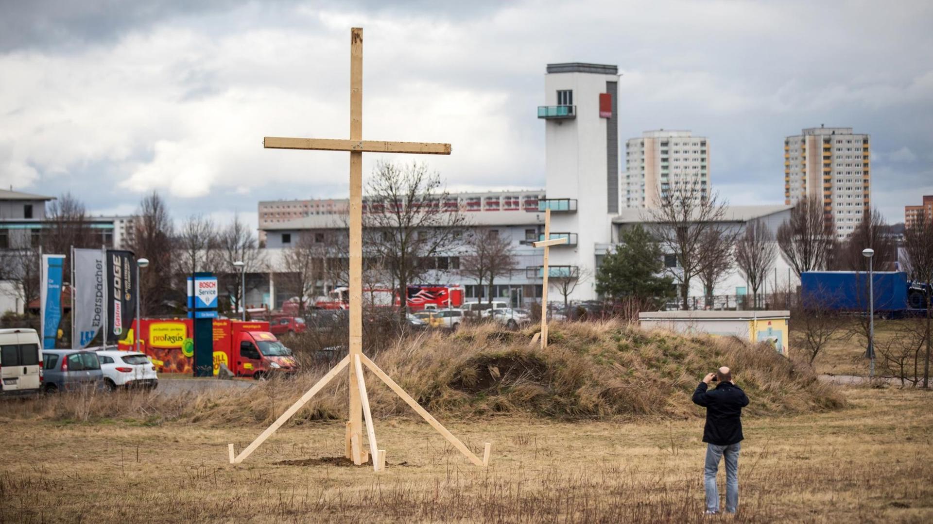 Eine Mann fotografiert in Erfurt ein großes Holzkreuz auf einem Grundstück in der Nähe der als Baugrund für den Moschee-Neubau vorgesehenen Fläche. Eine Mann fotografiert in Erfurt ein großes Holzkreuz auf einem Grundstück in der Nähe der als Baugrund für den Moschee-Neubau vorgesehenen Fläche.