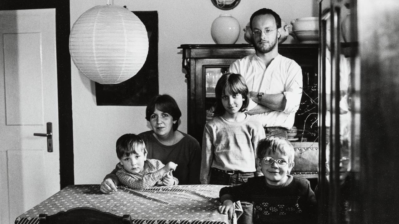 Foto einer fünfköpfigen Familie an ihrem Küchentisch. 