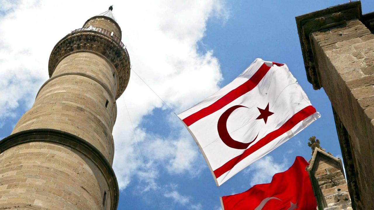 Eine türkische Flagge und eine Flagge der selbsterklärten Türkischen Republik von Nordzypern vor einer Moschee in Nicosia Eine türkische Flagge und eine Flagge der selbsterklärten Türkischen Republik von Nordzypern vor einer Moschee in Nicosia