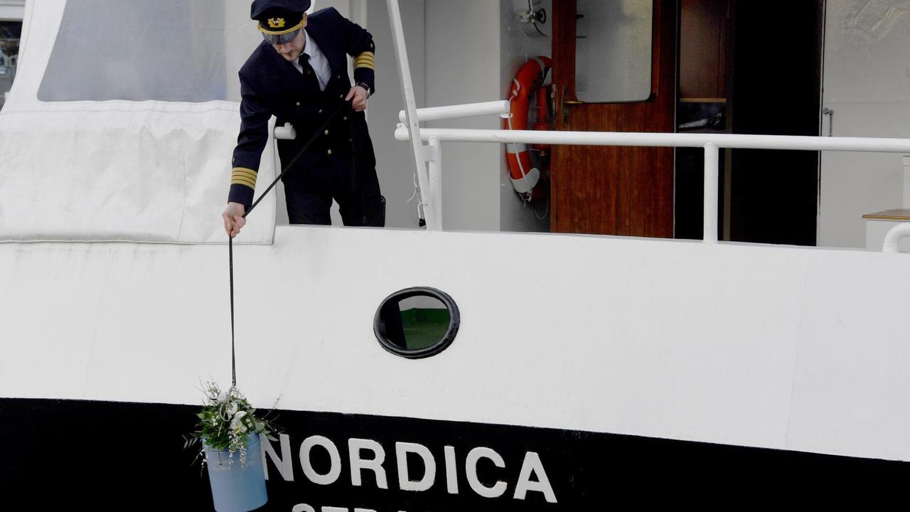 30.01.2018, Schleswig-Holstein, Strande: Norman Ludwig demonstriert an Bord seines Schiffes «Nordica» wie eine Urne zur Seebestattung ins Wasser gelassen wird. Nach Schätzung des Bundesverbandes Deutscher Bestatter gab es in Nord- und Ostsee im vergangenen Jahr fast 20 000 Bestattungen. 30.01.2018, Schleswig-Holstein, Strande: Norman Ludwig demonstriert an Bord seines Schiffes «Nordica» wie eine Urne zur Seebestattung ins Wasser gelassen wird. Nach Schätzung des Bundesverbandes Deutscher Bestatter gab es in Nord- und Ostsee im vergangenen Jahr fast 20 000 Bestattungen.