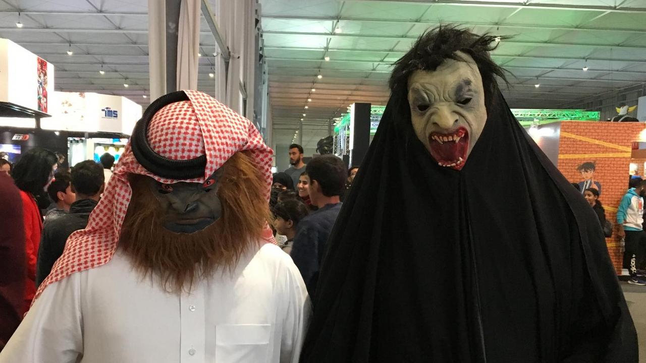 Das Bild zeigt einen Mann und eine Frau mit Masken auf der Comic Con in Riad.