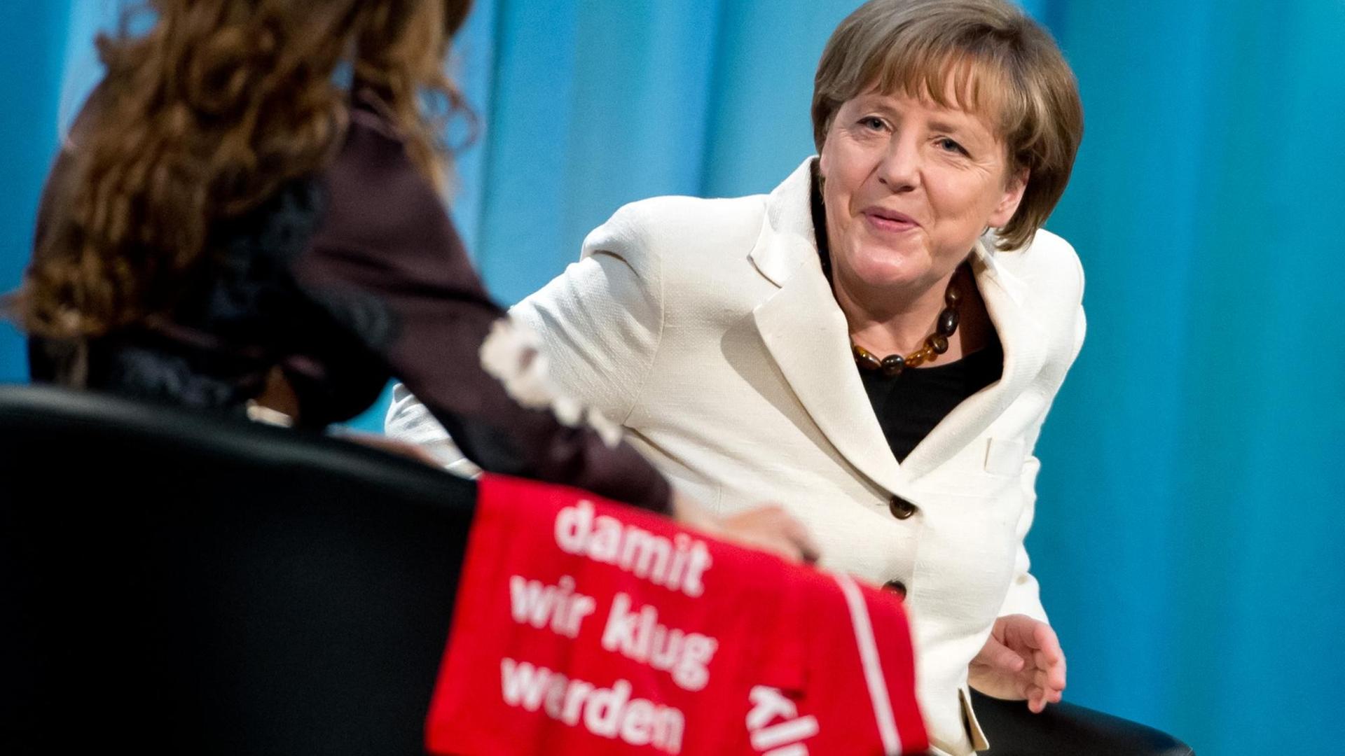 Angela Merkel auf einem Podium im Gespräch.