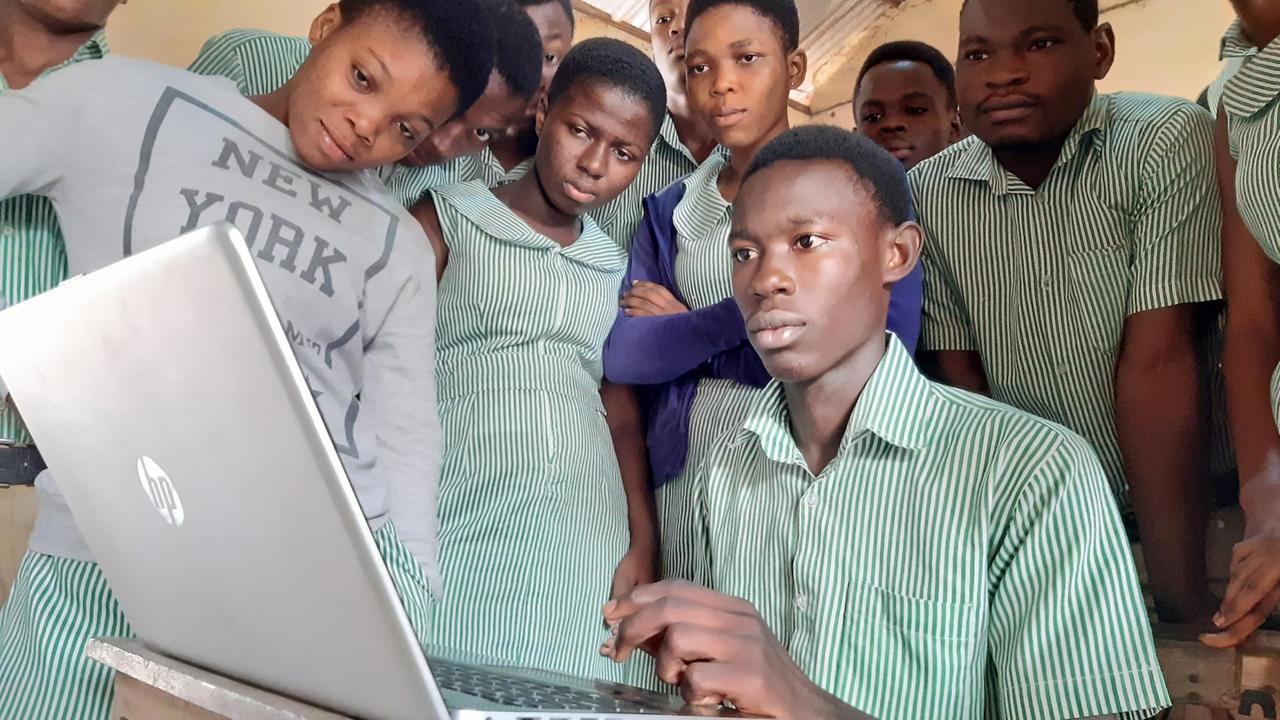 Schüler versammeln sich vor dem Laptop des Lehrers im ICT Unterricht. Schüler versammeln sich vor dem Laptop des Lehrers im ICT Unterricht.