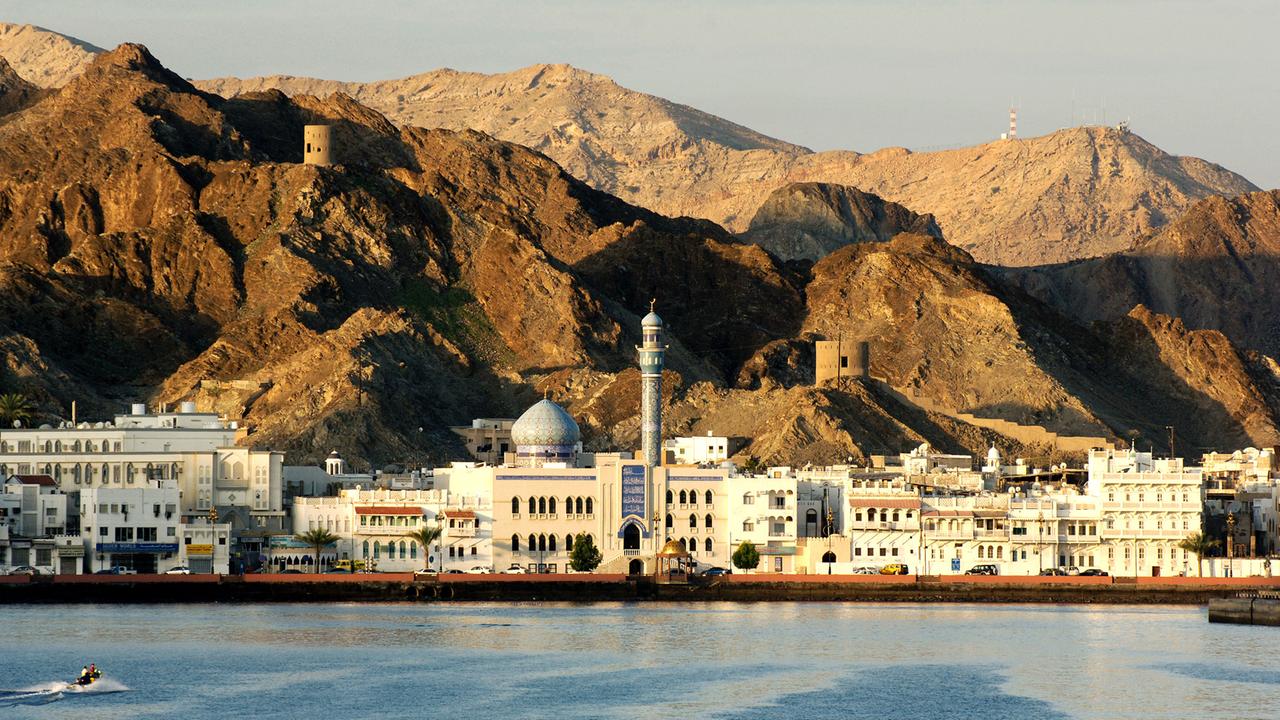 Sonnenaufgang über den Felsen und dem Altstadtviertel Mutrah von Muscat im Golf von Oman Sonnenaufgang über den Felsen und dem Altstadtviertel Mutrah von Muscat im Golf von Oman