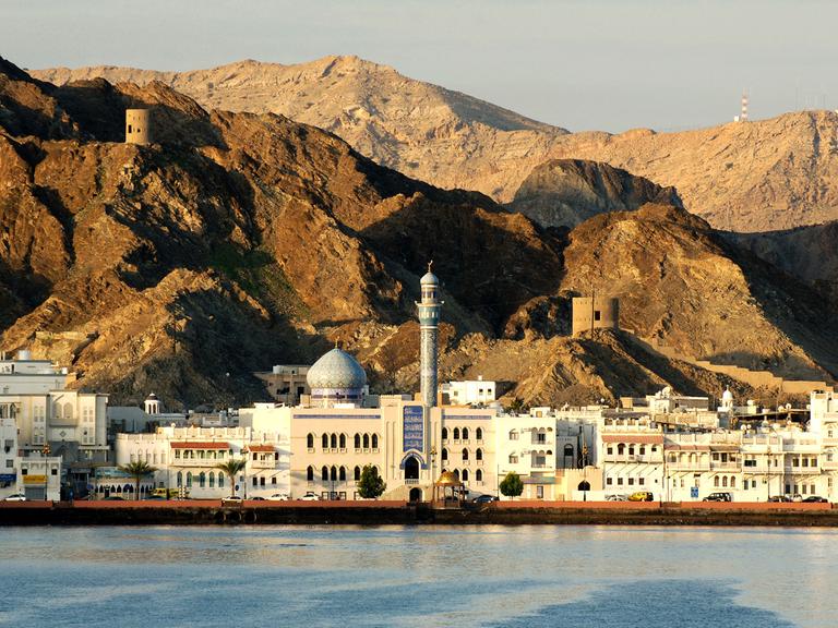 Sonnenaufgang über den Felsen und dem Altstadtviertel Mutrah von Muscat im Golf von Oman