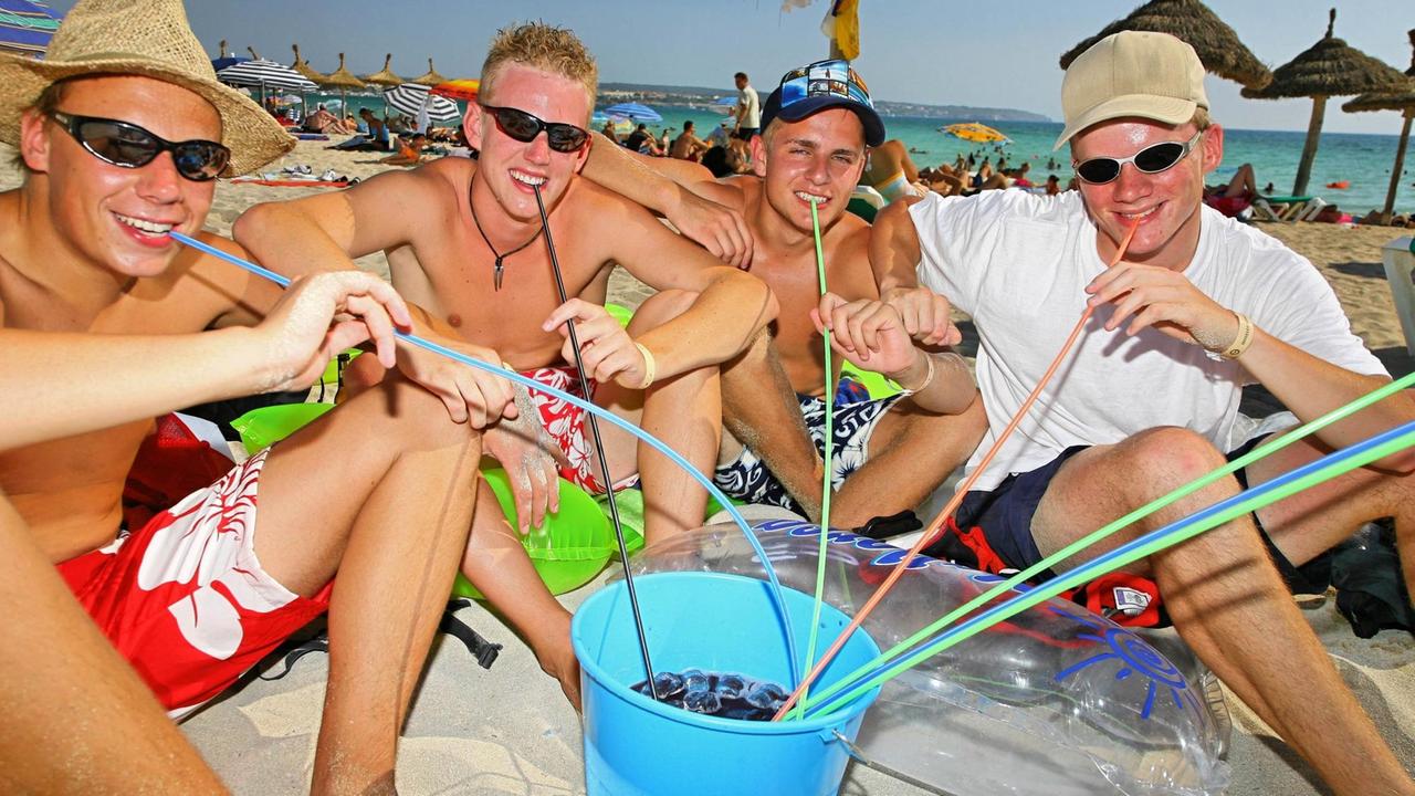 Eine trinkende Männergruppe am Strand von Mallorca.