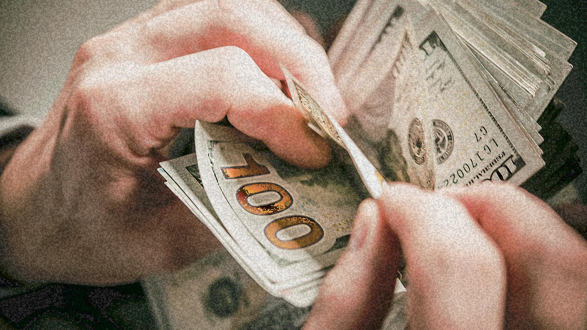 Eine Person zählt die Geldscheine in ihrer Hand. Eine Person zählt die Geldscheine in ihrer Hand.