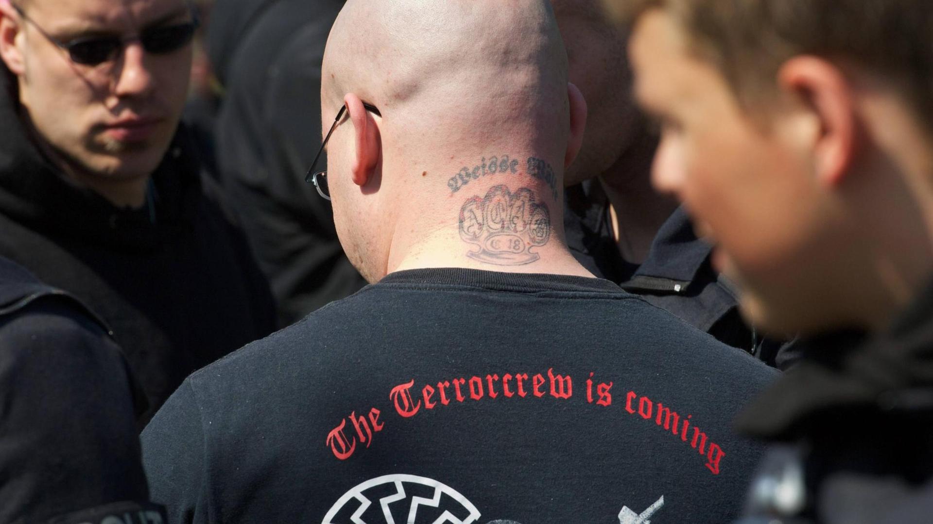 Ein Mann mit einem Tattoo der "Weiße Wölfe Terrorcrew" auf einer Neonazi-Demonstration in Wittstock. Ein Mann mit einem Tattoo der "Weiße Wölfe Terrorcrew" auf einer Neonazi-Demonstration in Wittstock.