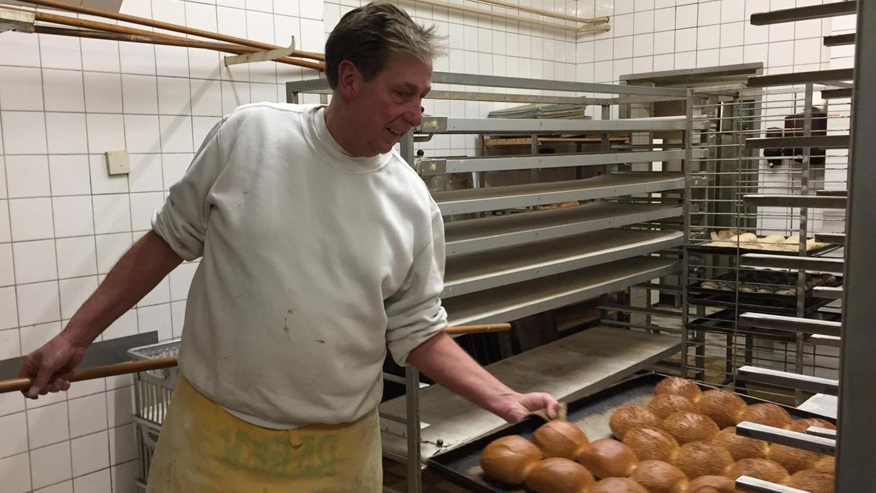 Michael Ratjen holt ein Backblech aus dem Ofen