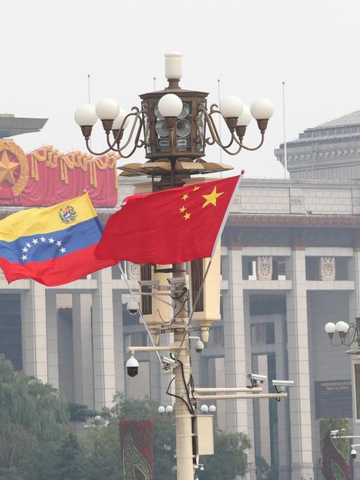 Chinesische und venezolanische Nationalflaggen flattern auf dem Laternenpfahl während eines viertägigen Besuchs des venezolanischen Präsidenten Nicolas Maduro in Peking, China, 14. September 2018.