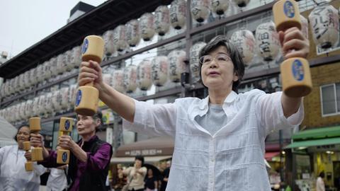 Elderly people work out with wooden dumb-bells in the grounds of a temple in Tokyo on September 19, 2016, to celebrate Japan's Respect for the Aged Day. / AFP PHOTO / KAZUHIRO NOGI