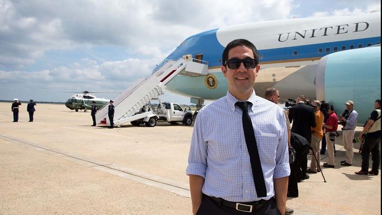 Ein junger Mann mit Sonnenbrille, kurzärmligem Hemd und schwarzer Krawatte steht am Flughafen vor der Maschine des US-Präsidenten. Ein junger Mann mit Sonnenbrille, kurzärmligem Hemd und schwarzer Krawatte steht am Flughafen vor der Maschine des US-Präsidenten.
