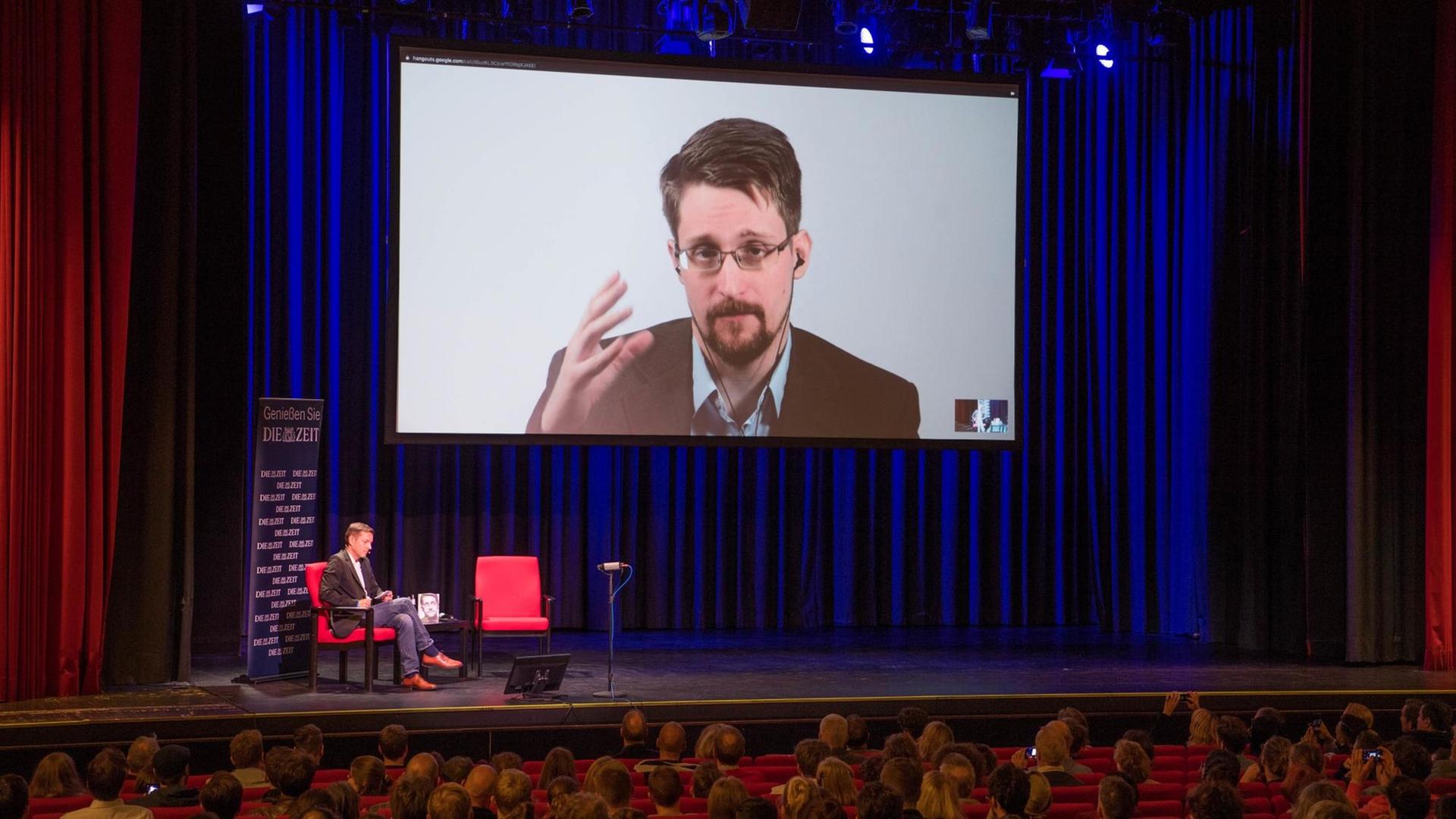 Edward Snowden ist im September 2019 auf einer Video-Leinwand in der Urania in Berlin zu sehen, während er bei einer Liveübertragung über sein Buch "Permanent Record: Meine Geschichte" spricht.