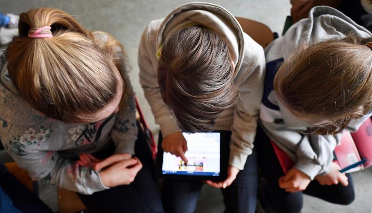 Schüler arbeiten mit einem Tablet.