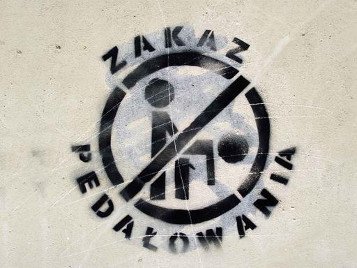 An einem Haus im Stadtzentrum von Warschau ist ein Graffiti mit der Abbildung zweier Homosexueller beim Geschlechtsverkehr zu sehen mit der Überschrift "Zakaz Pedalowania - Verbietet Pädophilie".
