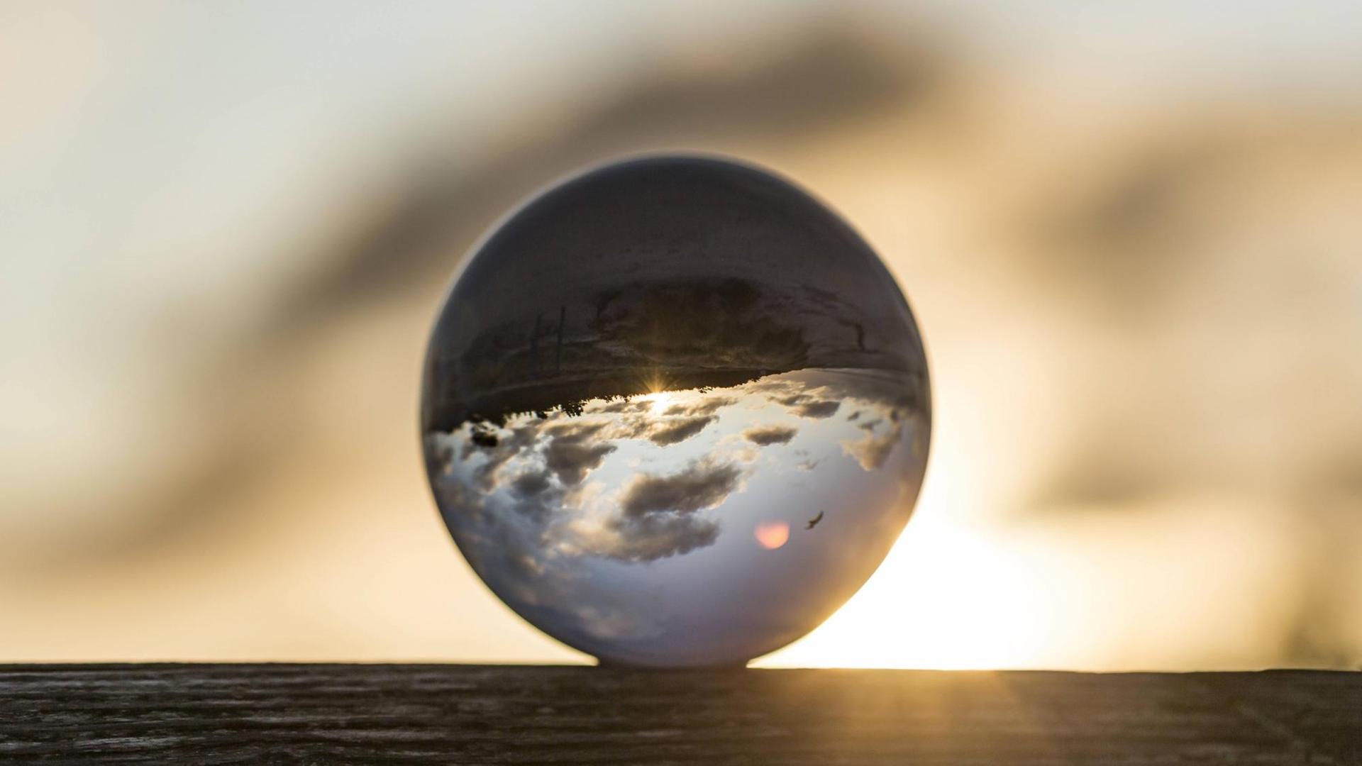 Eine Glaskugel, in der sich der Himmel und Wolken seitenverkehrt spiegeln. Eine Glaskugel, in der sich der Himmel und Wolken seitenverkehrt spiegeln.