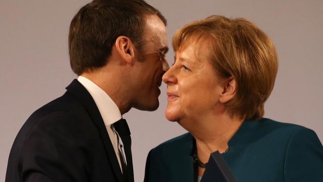 Emmanuel Macron, Präsident von Frankreich, und Bundeskanzlerin Angela Merkel (CDU), umarmen sich nach der Unterzeichnungszeremonie des neuen deutsch-französischen Freundschaftsvertrags im Krönungssaal des Rathauses.