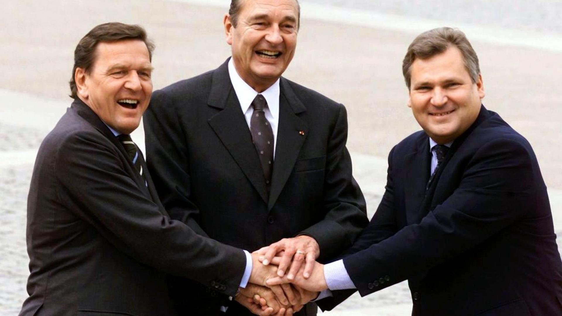 Bundeskanzler Gerhard Schröder, der französische Staatspräsident Jacques Chirac und sein polnischer Kollege Alexander Kwasniewski geben sich am 7.5.1999 in Nancy die Hand.
