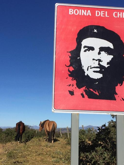 Ein Schild mit Che Guevara im bolivianischen Hinterland neben Pferden. Ein Schild mit Che Guevara im bolivianischen Hinterland neben Pferden.