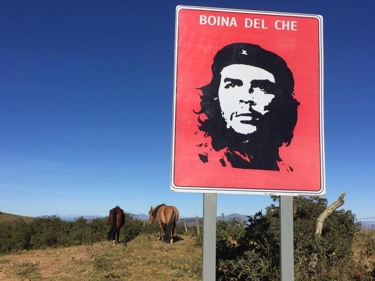Ein Schild mit Che Guevara im bolivianischen Hinterland neben Pferden. Ein Schild mit Che Guevara im bolivianischen Hinterland neben Pferden.