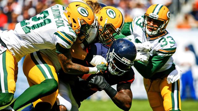 Drei Spieler der Green Bay Packers attackieren den Angriffsspieler der Chicago Bears