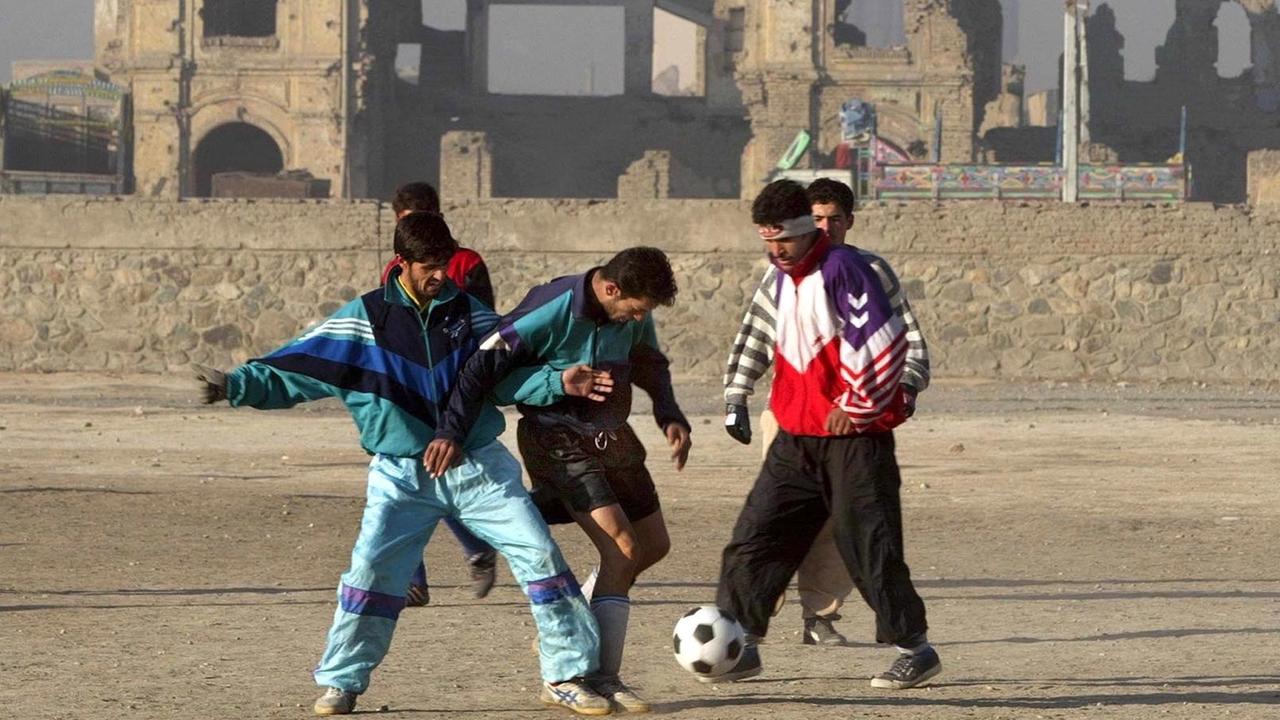 Männer spielen im Januar 2002 in dem zerstörten Stadion von Kabul Fußball. Männer spielen im Januar 2002 in dem zerstörten Stadion von Kabul Fußball.
