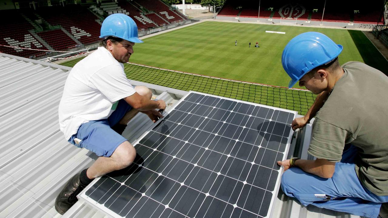 Alternative Energie auch in der Bundesliga: Auf dem Dach des Mainzer Bruchwegstadions befestigen zwei Bauarbeiter ein Modul einer Solaranlage. Alternative Energie auch in der Bundesliga: Auf dem Dach des Mainzer Bruchwegstadions befestigen zwei Bauarbeiter ein Modul einer Solaranlage.