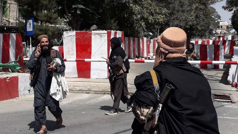 Mitglieder der Taliban vor einr Straßenabsperrung Mitglieder der Taliban vor einr Straßenabsperrung