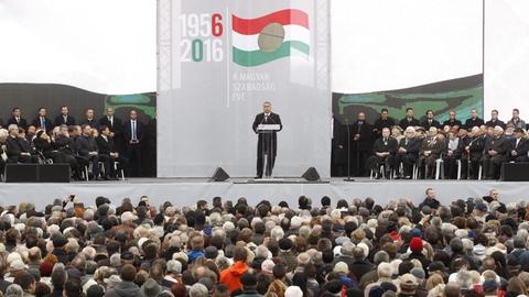 Der ungarische Ministerpräsident Orban steht auf einem Podium vor dem Parlament in Budapest und hält eine Rede anlässlich des Volksaufstandes von 1956.