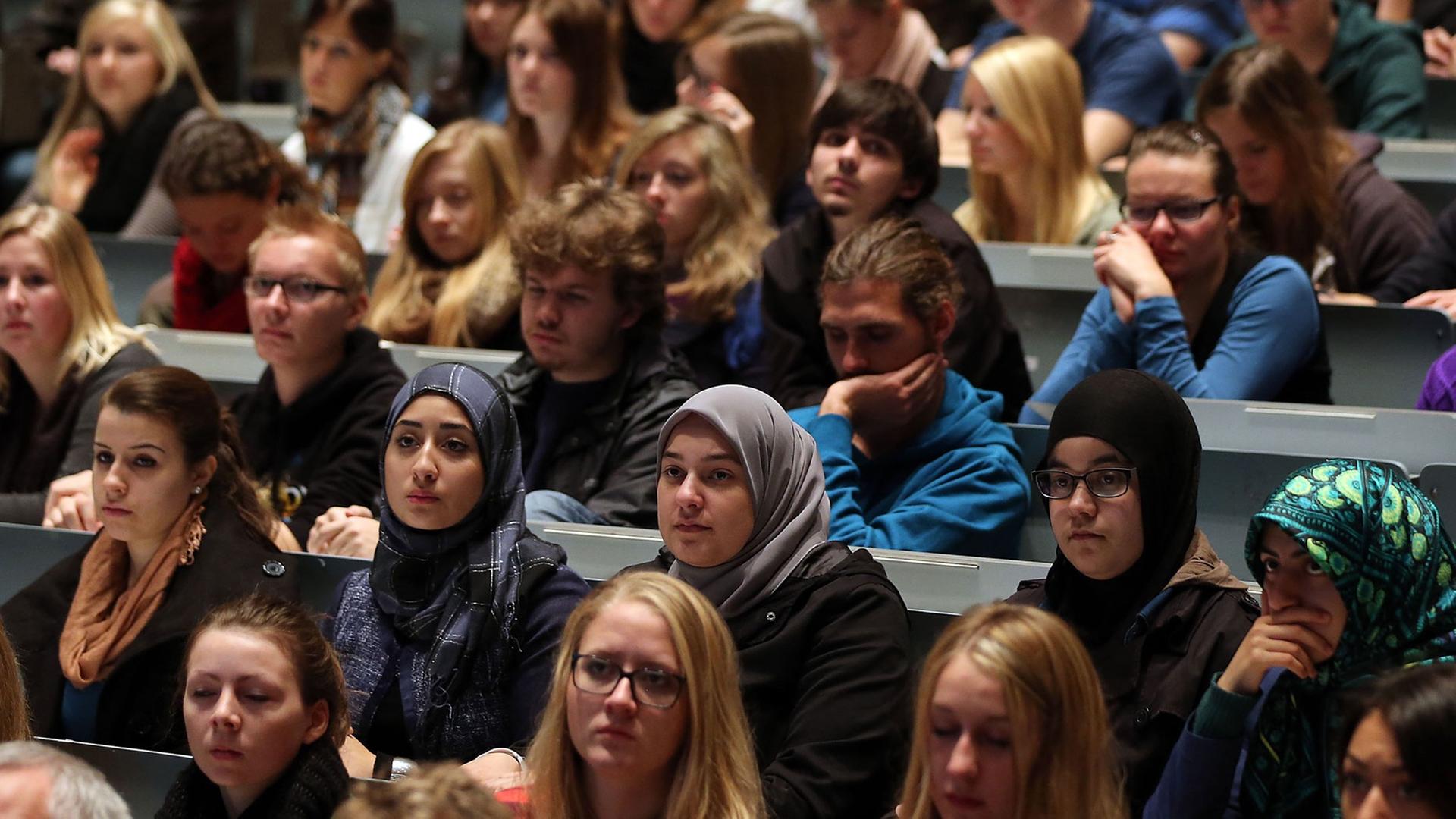 Studenten verfolgen in Köln in der Aula Universität eine Veranstaltung. Studenten verfolgen in Köln in der Aula Universität eine Veranstaltung.