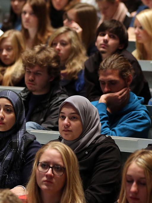 Studenten verfolgen in Köln in der Aula Universität eine Veranstaltung.