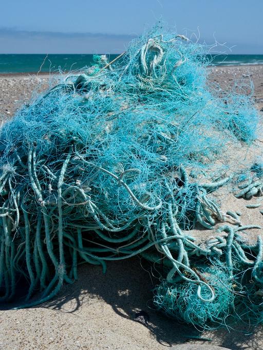 Am Nordseestrand an der Westküste von Dänemark nahe dem Ort Agger liegt ein Haufen vom Meer angespülter Fischernetze und Seile.