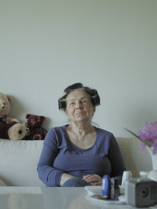 Porträt von Christel auf dem Sofa sitzend mit Lockenwicklern in den Haaren