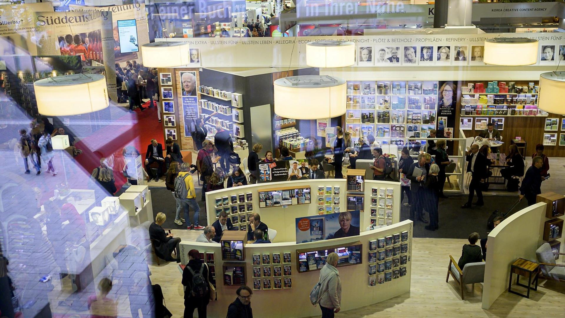 Blick in eine Ausstellungshalle der Frankfurter Buchmesse aus dem Jahr 2019. Überall sind Stände zu sehen, Menschen gehen dazwischen hindurch. Blick in eine Ausstellungshalle der Frankfurter Buchmesse aus dem Jahr 2019. Überall sind Stände zu sehen, Menschen gehen dazwischen hindurch.
