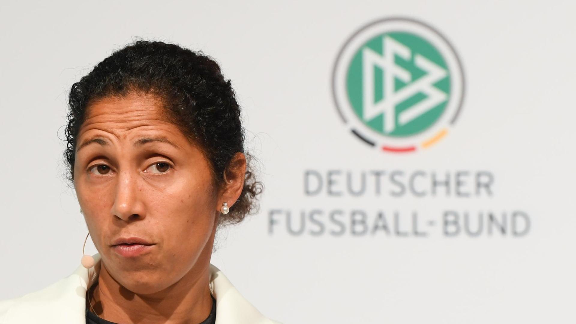 Steffi Jones vor dem Logo vom Deutschen Fußball-Bund Steffi Jones vor dem Logo vom Deutschen Fußball-Bund