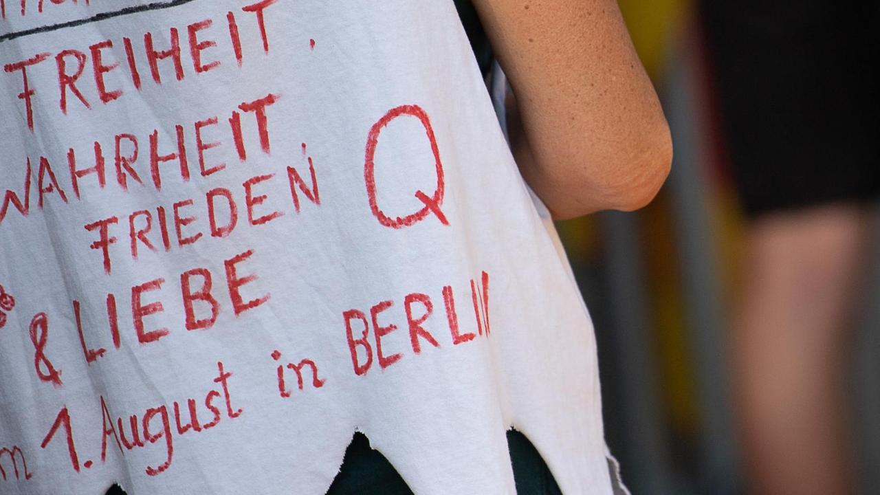 Eine Frau trägt während einer Kundgebung der Initiative «Querdenken 711» im unteren Schlossgarten, die sich gegen die Corona-Maßnahmen richtet, ein Shirt mit der Aufschrift «Freiheit, Wahrheit, Frieden & Liebe» sowie «Q». Eine Frau trägt während einer Kundgebung der Initiative «Querdenken 711» im unteren Schlossgarten, die sich gegen die Corona-Maßnahmen richtet, ein Shirt mit der Aufschrift «Freiheit, Wahrheit, Frieden & Liebe» sowie «Q».