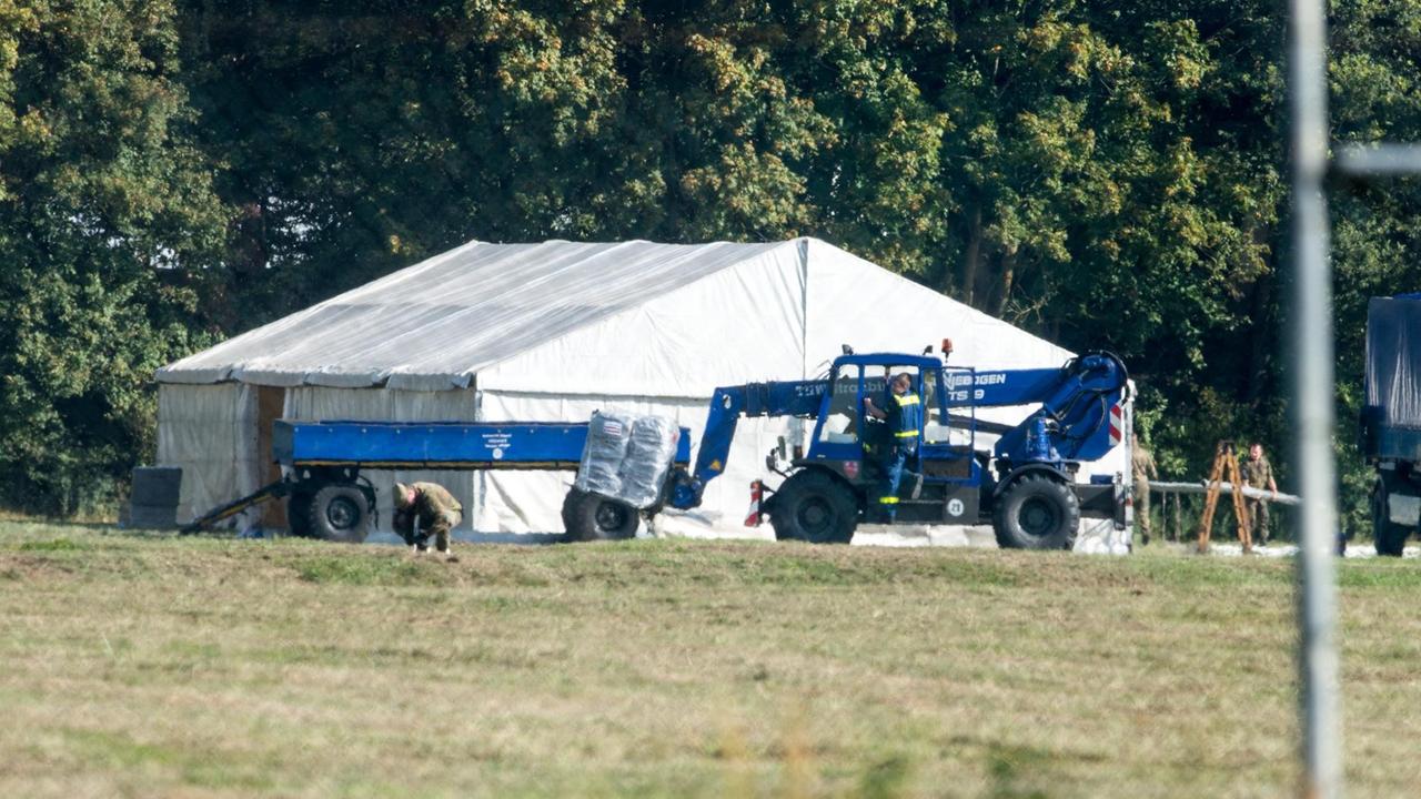 THW-Helfer und Bundeswehrsoldaten bauen auf einem Gelände in Feldkirchen nahe Straubing im September 2015 Zelte auf. THW-Helfer und Bundeswehrsoldaten bauen auf einem Gelände in Feldkirchen nahe Straubing im September 2015 Zelte auf.