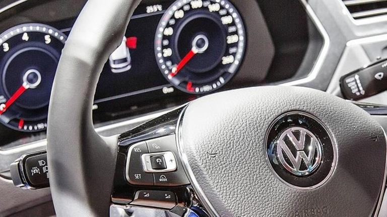 Das Bild zeigt ein Lenkrad eines VW-Autos mit Teilen des Amaturenbretts. Das Bild zeigt ein Lenkrad eines VW-Autos mit Teilen des Amaturenbretts.