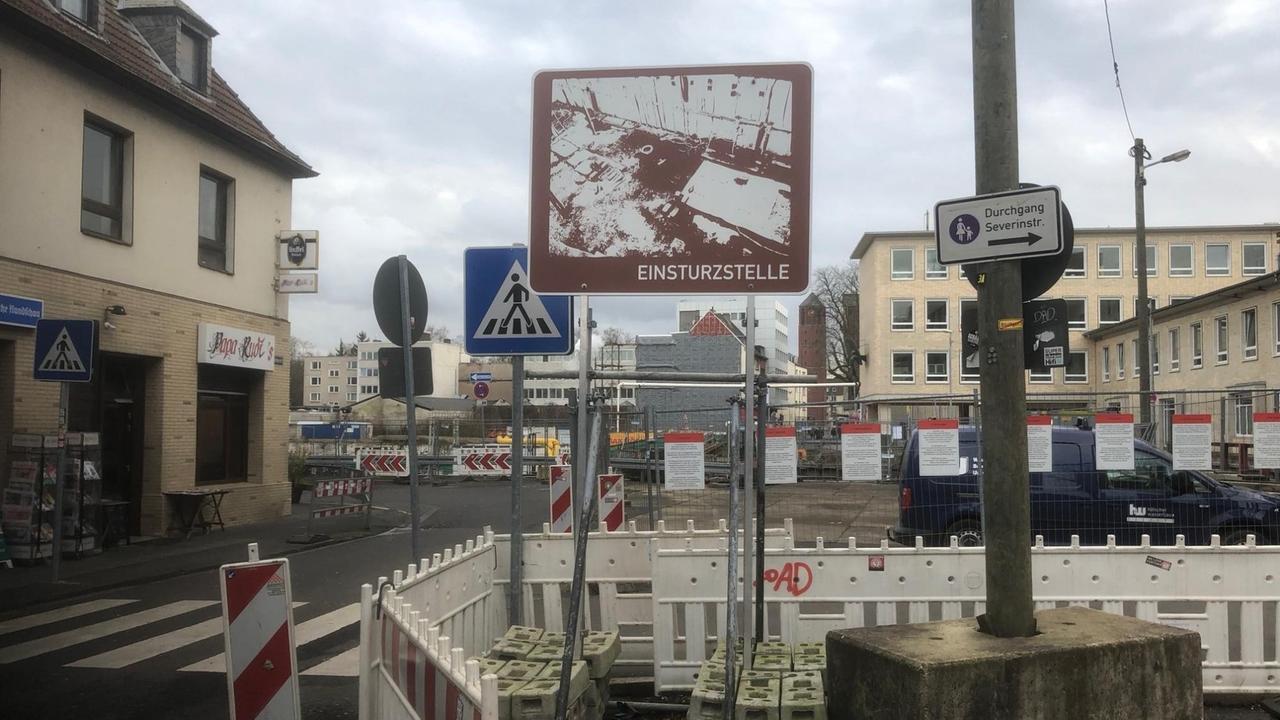 "Einsturzstelle" steht auf einem braun weißen Schild, dort wo das ehemalige Kölner Stadtarchiv eingebrochen ist.